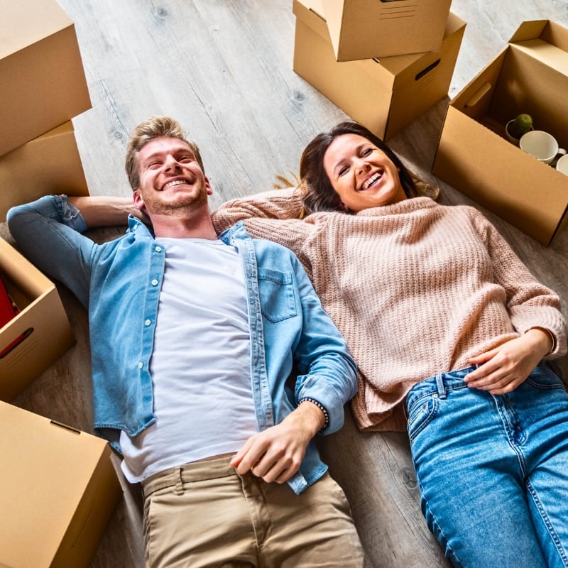 happy couple surrounded by boxes moving with Austate Removals
